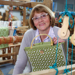 Starsza kobieta trzymająca w dłoni zieloną torbę z tkaniny