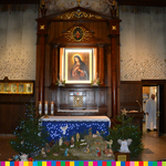 Wnętrze kościoła z obrazem Matko Boskiej w ołtarzu głównym. Pod ołtarzem szopka bożonarodzeniowa.