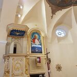 Zawieszony an wyremontowanej ścianie obraz Jana Pawła II w kościele w Strabli