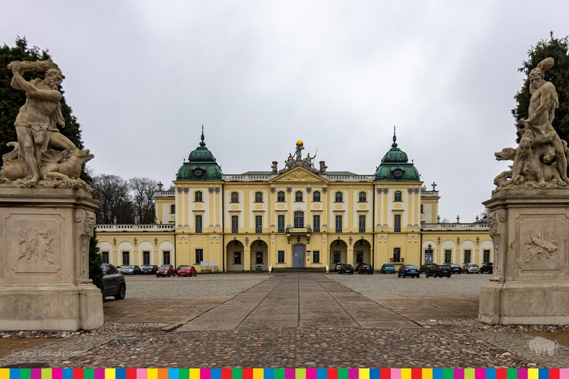 Widoczny Pałac Branickich wraz z bramą wjazdową, na której cokołach stoją pomniki