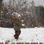 Uśmiechnięte dziecko bawiące się w śniegu