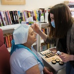 Wolontariuszka ze Stowarzyszenia Eurydyki wykonuje makijaż pacjentce Centrum Onkologii.