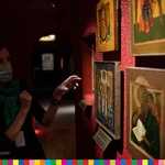 Dyrektor Muzeum Ikon w Supraślu wskazuje ręką w kierunku obrazów sakralnych