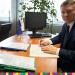 Marek Malinowski w trakcie podpisywania umowy.