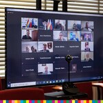 Ekran monitora z małymi ekranami radnych, biorących udział w sesji online.