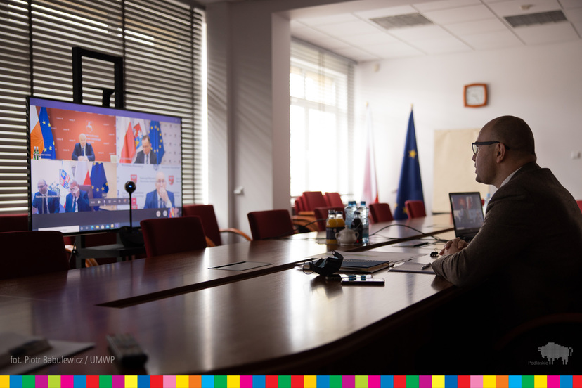 Artur Kosicki, Marszałek Województwa Podlaskiego przed ekranem, na którym widać uczestników spotkania online.