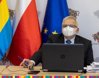 Bogusław Dębski, przewodniczący Sejmiku. W tle flaga Województwa Podlaskiego, Polski i UE