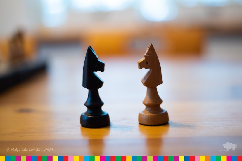 Dwie figury szachowe w czarnym i białym kolorze stojące na przeciwko siebie