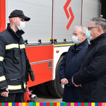 Wicemarszałek Marek Olbyrś oraz dwóch mężczyzn stoją przy wozie strażackim