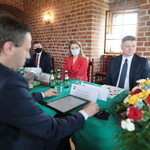 Członek Zarządu, Marek Malinowski siedzi przy stole wraz z innymi osobami
