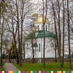 Cerkiew ze złotą kopułą za drzewami.