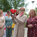 Pięć kobiet. Jedna z nich trzyma statuetkę z sercem - logo Fundacji Pomóż Im