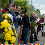 Tomasz Szeweluk, Sekretarz Województwa Podlaskiego trzyma wieniec kwiatów. Obok niego stoją ludzie uczestniczący w wydarzeniu