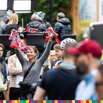 Widoczny tłum kibiców. Spośród zgromadzenia widoczna dziewczyna trzymająca w ręku rzecz w barwach flagi norweskiej