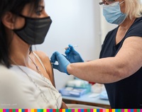 Kobieta szczepiona w punkcie szczepień przez pielęgniarkę