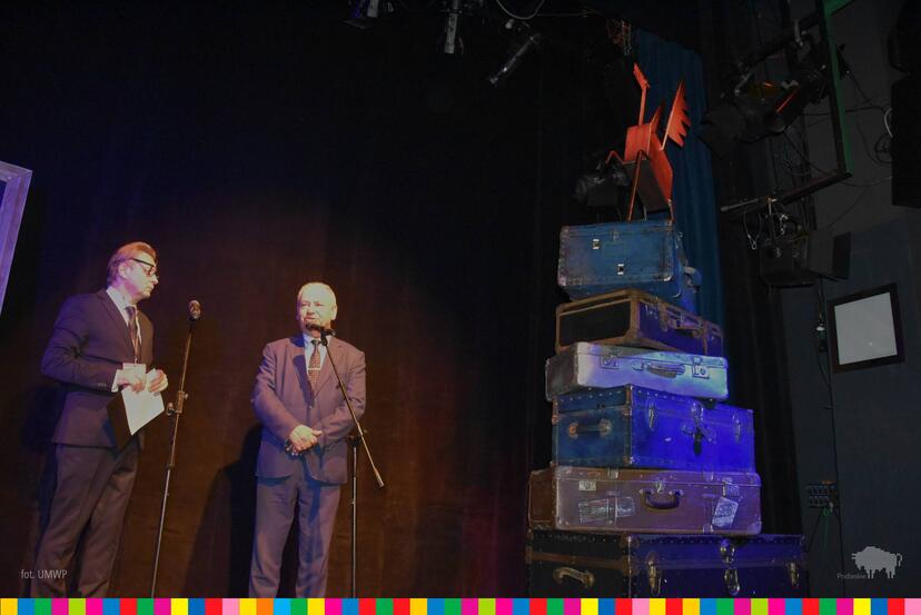 Dwóch mężczyzn stojących na scenie podczas otwarcia 34. Międzynarodowego Festiwalu Walizka. Obok nich stoją walizki