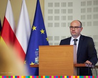 Marszałek Kosicki  przy mówinicy. Po lewej flagi: unijna, polska i województwa.