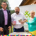 Trzy osoby pozujące do zdjęcia z umową, wśród nich wicemarszałek Stanisław Derehajło i beneficjenci
