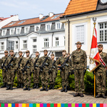 Żołnierze stoją na placu pod budynkiem