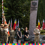 Żołnierze stoją na placu pod pomnikiem