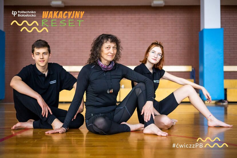 Trzy osoby w strojach sportowych siedzą na podłodze sali gimnastycznej