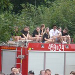 Młodzież na dachu wozu strażackiego.