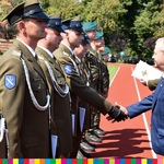 wicemarszałek Marek Olbryś podaje dłoń mężczyźnie w mundurze