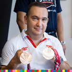 Mistrz olimpijski trzymający w dłoniach dwa medale
