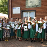kobiety w strojach ludowych stoja przed Izbą Tkactwa Dwuosnowego w Janowie