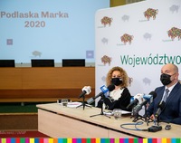 Magdalena Łyżnicka-Sanczenko oraz marszałek Artur Kosicki siedzą za stołem zastawionym mikrofonami