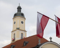 Flaga biało-czerwona. Na drugim planie wieża Ratusza