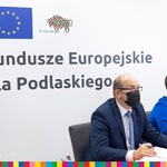 Mężczyzna i kobieta przy stole, w tle napis: Fundusze Europejskie dla Podlaskiego