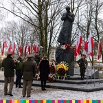 Osoby stoją przed pomnikiem bł. księdza Jerzego Popiełuszki i składają wieniec przed pomnikiem