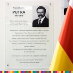Tablica z biogramem Krzysztofa Putry. Z prawej strony widoczny kawałek flagi Województwa Podlaskiego