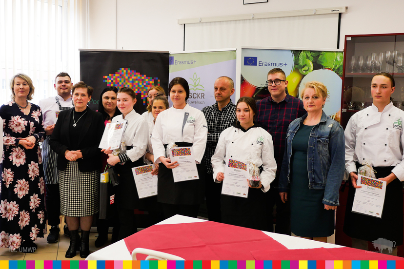 Wiesława Burnos oraz osoby uczestniczące w konkursie Gotuj z Klasą pozują do wspólnego zdjęcia