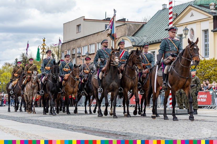 Żołnierze ubrani w historyczne mundury i jadą na koniach