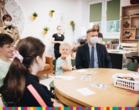 Marek Malinowski siedzi z dziećmi przy stole