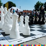Białe i czarne figury stoją na biało-czarnej szachownicy