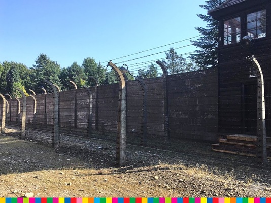 Mury obozu Auschwitz-Birkenau otoczone drutami kolczastymi